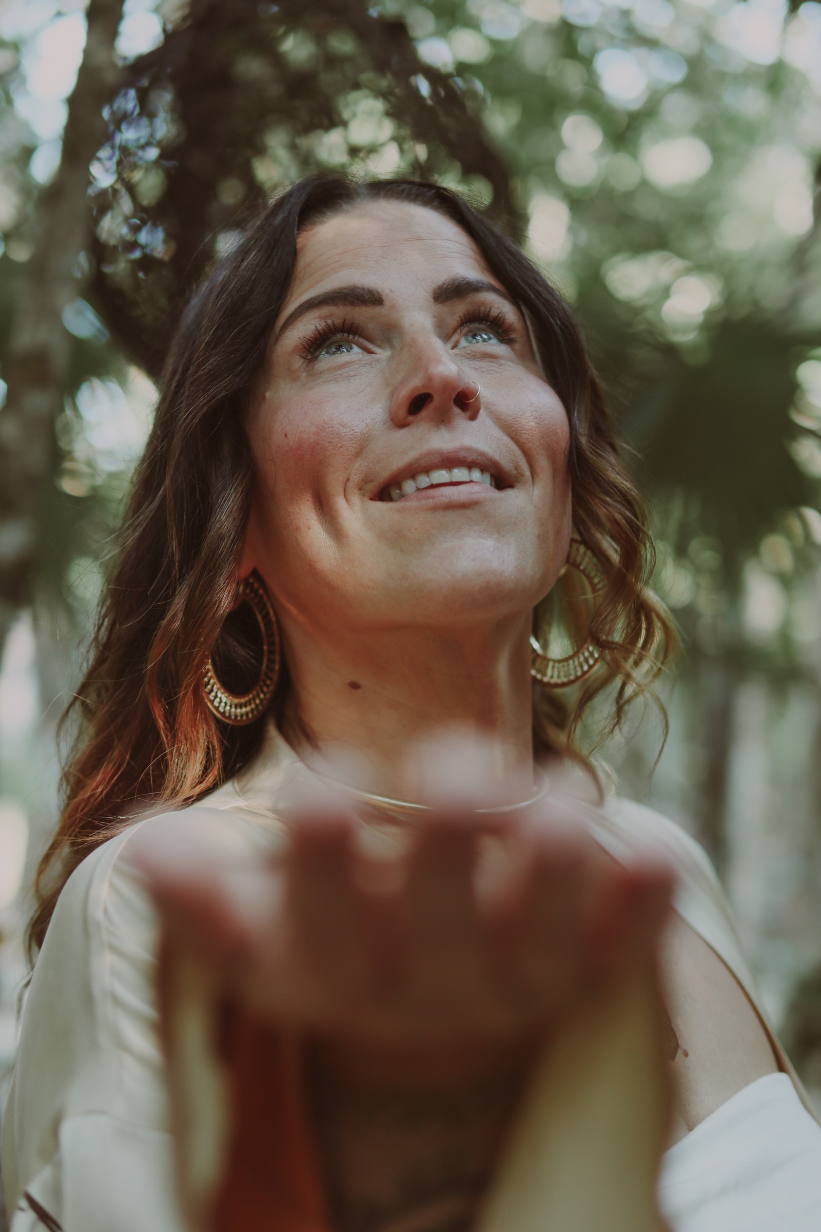 Kate Gajewski holding her hands forward beneath the trees